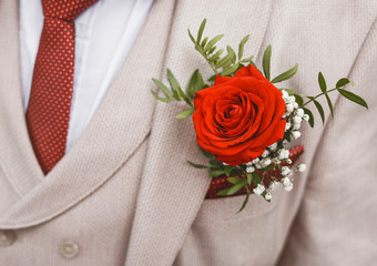 Men's wedding luxury suit in beige, white or gray color decorated with a rose, close-up