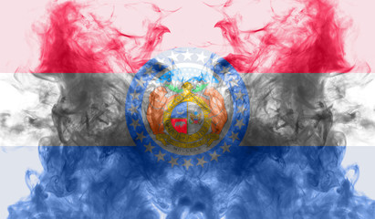 The national flag of the US state Missouri in against a gray smoke on the day of independence in different colors of blue red and yellow. Political and religious disputes, customs and delivery.