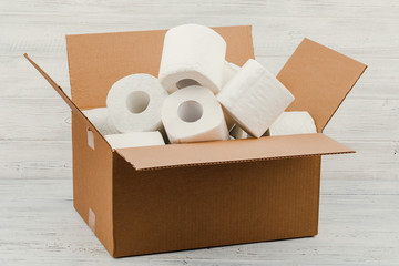 Toilet paper rolls in a cardboard box on a white background
