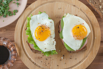 sandwiches with sits and greens on a wooden board