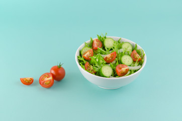 Salad bowl with frisee lettuce, baby tomato, cucumber, onion... Healthy foods concept
