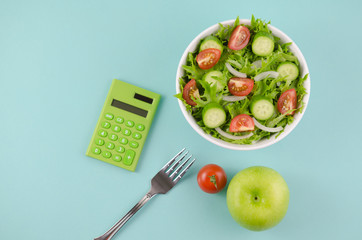 Diet concept image. Fresh salad and vegetable, calculator and measuring tab