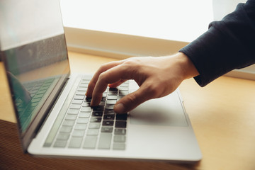 Close-up of male fingers typing a business document, note or search key on the laptop. Business, finance, education, working and online shopping or surfing concept.