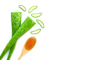 Closeup green fresh organic aloe vera leaves and pure honey in wooden spoon isolated on white background. Top view. Flat lay.