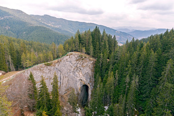 Through passage in the mountain range. Tall slender fir trees grow on the mountain 
slopes.
