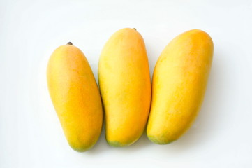 Three yellow mangoes on a white background.