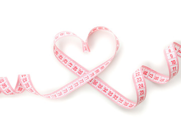 Measuring tape in the form of heart isolated on white background