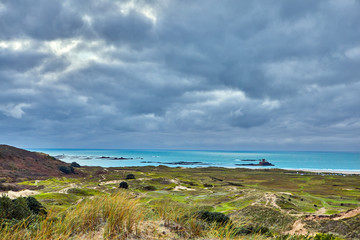 Image of St Ouens Bay with sand dunes and cloudy sky