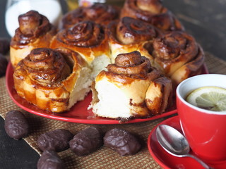 Home cooking. Freshly baked rolls with chocolate filling and a Cup of tea with lemon on an ancient wooden table.