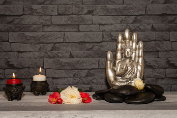 Statue de Bouddha sur fond d'un mur de pierre.	