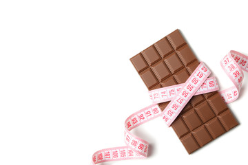 Measuring tape and chocolate bar on white background