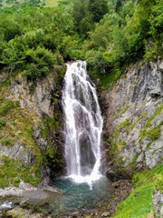 Fototapeta na wymiar Beautiful waterfall with crystal clear waters in the mountains