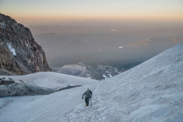 man hiking up a glacier on mount hood oregon