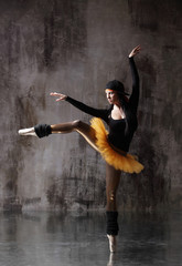 Young beautiful ballerina is posing in studio