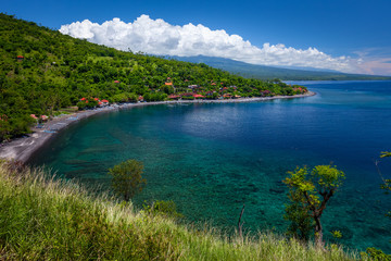 Fototapeta na wymiar Green and hilly coastline of Bali island in the area of Amed village, Indonesia