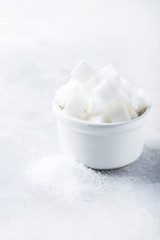 Sugar cubes and grain of sugar