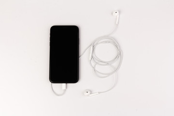 Creative flat lay photo of workspace desk with earphones and mobile phone