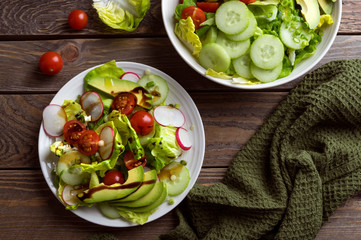 Fresh spring salad with lettuce, cucumber, cherry tomatoes, radishes, spring onion and avocado topped with balsamic glaze and extra virgin olive oil.