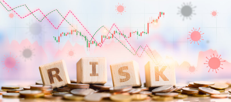 Wood block word RISK on coins stack. Financial risk concept. Money management, interest rates. Economic crisis. Coronavirus scares stock market investors.