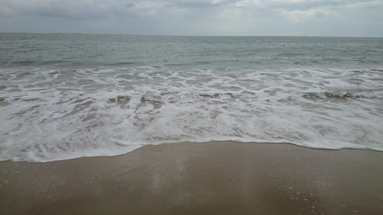 sea ??horizon, waves with foam run onto yellow sand