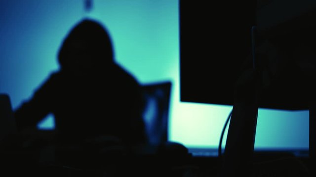A computer programmer or hacker prints a code on a laptop keyboard to break into a secret organization system.