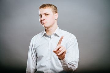 a young and handsome businessman pointing up with his finger