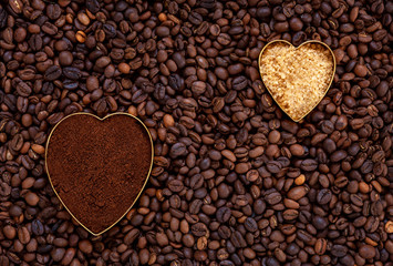 Heart shaped fresh ground coffee and cane sugar on coffee beans background
