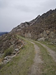 Fototapeta na wymiar Winding grassy road in the Mountain with stones