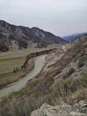 Fototapeta na wymiar Meandering river flowing between high mountains
