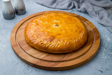 Ossetian pie with meat on grey stone table