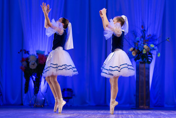 Young girls ballerina in a blue and white costume dancing ballet performance on stage in a theater © Kozlik_mozlik