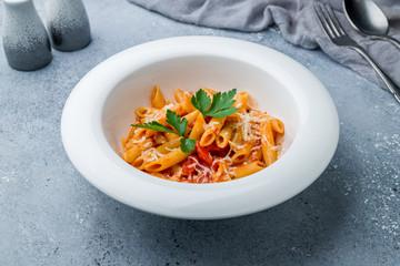 Pasta Penne arabiata on grey table