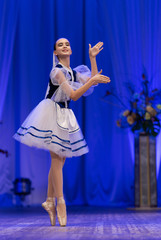 Young girls ballerina in a blue and white costume dancing ballet performance on stage in a theater © Kozlik_mozlik