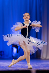 Young girls ballerina in a blue and white costume dancing performance on stage in a theater © Kozlik_mozlik