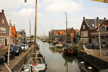 Dutch canal with sailing boats and typical houses
