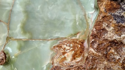 Green onyx tile with orange weaves. Background texture for design.