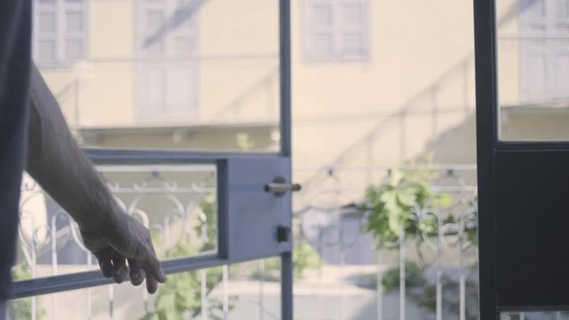 Hand opening glass door. Masculine strong veiny arm close up. going outside after corona quarantine. street view