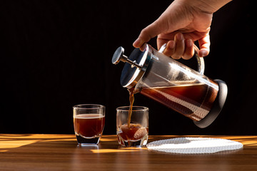 Coffee brewing in a French press pot and two donuts in plate on the wood table and warm morning...