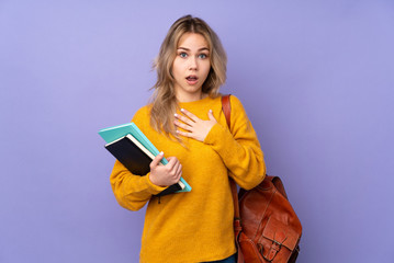 Teenager Russian student girl isolated on purple background surprised and shocked while looking right