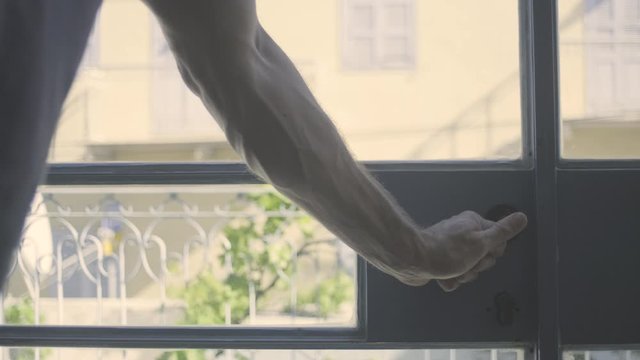 Guy closing a glass door. Masculine  veiny arm shutting the entrance