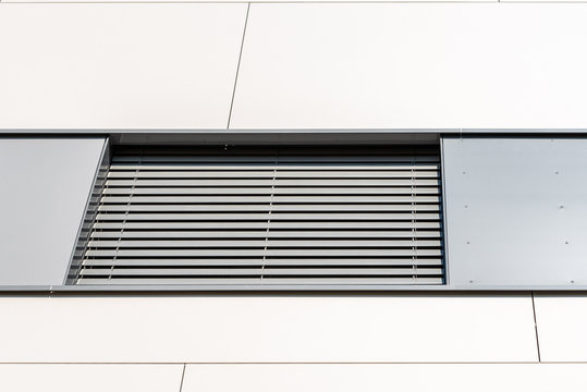 Detail of modern residential building with venetian blinds in windows on ceramic ventilated facade.