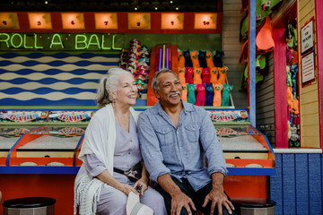 Smiling senior couple resting by a game booth