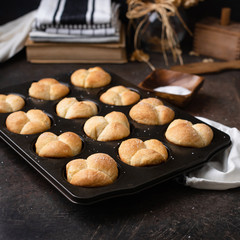 Freshly Baked Homemade Cloverleaf Rolls in Muffin Tin: Rustic, Dark Background