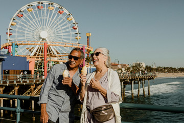 Happy seniors enjoying ice cream by the sea