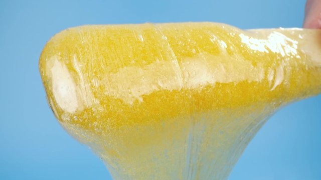 Beauty and body care concept. Liquid yellow sugar paste or wax for depilation on a blue background
