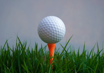 Golf ball on tee in the evening golf course with sunshine.