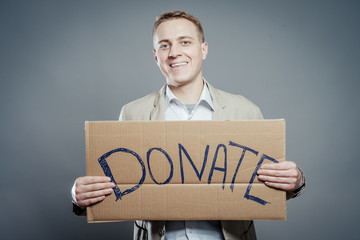 man holding Cardboard text a donate