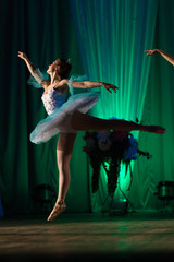 Young girl ballerina in a light blue dress tutu dancing performance of a ballet on stage in a theater © Kozlik_mozlik