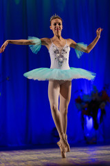 Young girl ballerina in a light blue dress tutu dancing performance of a ballet on stage in a theater © Kozlik_mozlik