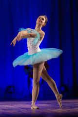 Young girl ballerina in a light blue dress tutu dancing performance of a ballet on stage in a theater © Kozlik_mozlik